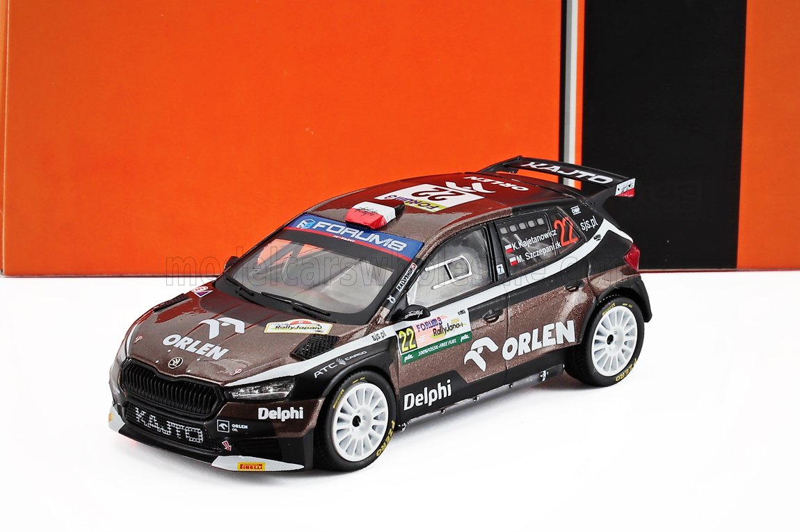 Modèle réduit détaillé à l'échelle 1:43 d'une voiture de rallye Škoda sponsorisée par Orlen, avec des roues blanches et une livrée rouge et noire, également disponible via Vroomi.