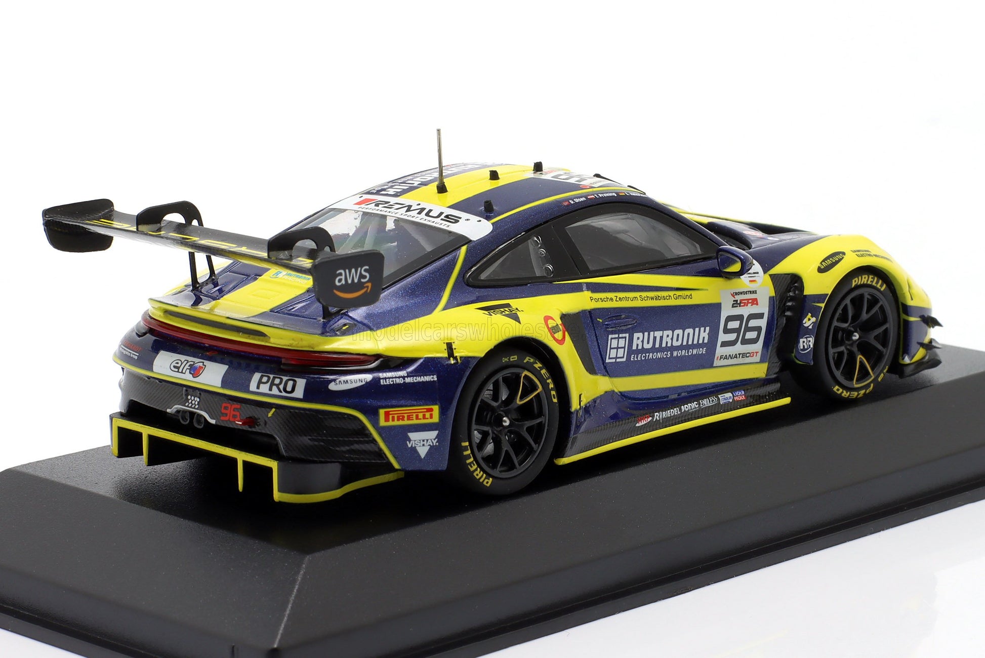 Modèle réduit de voiture de course Porsche GT3 bleu et jaune à l'échelle 1:18 avec livrée détaillée, disponible chez Vroomi.