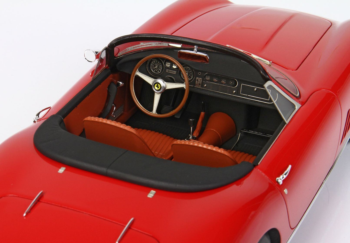 Red vintage convertible car interior with brown seats and wooden Ferrari steering wheel, featured on Vroomi