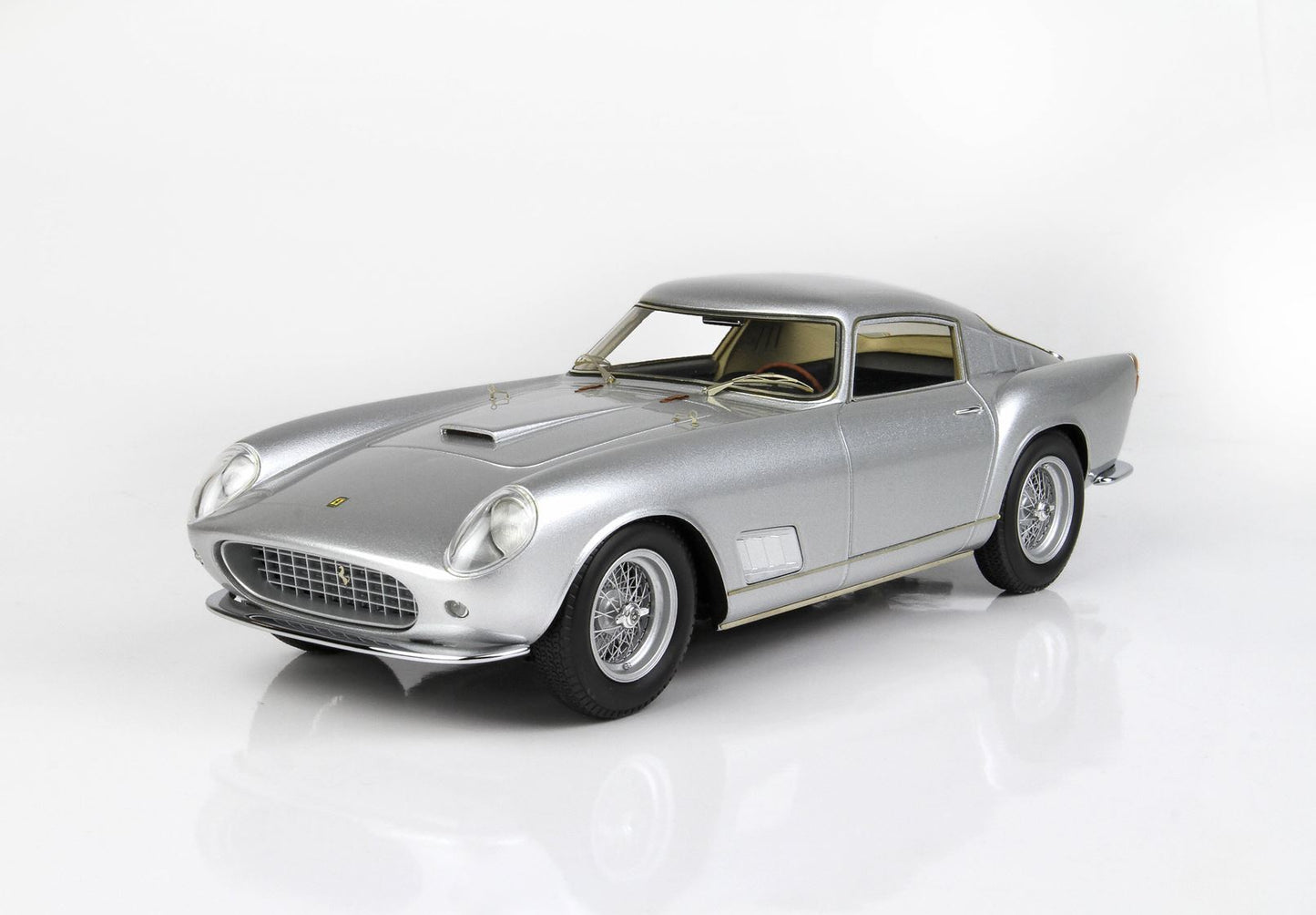 Silver classic sports car model with wire wheels and detailed front grille, offered on Vroomi
