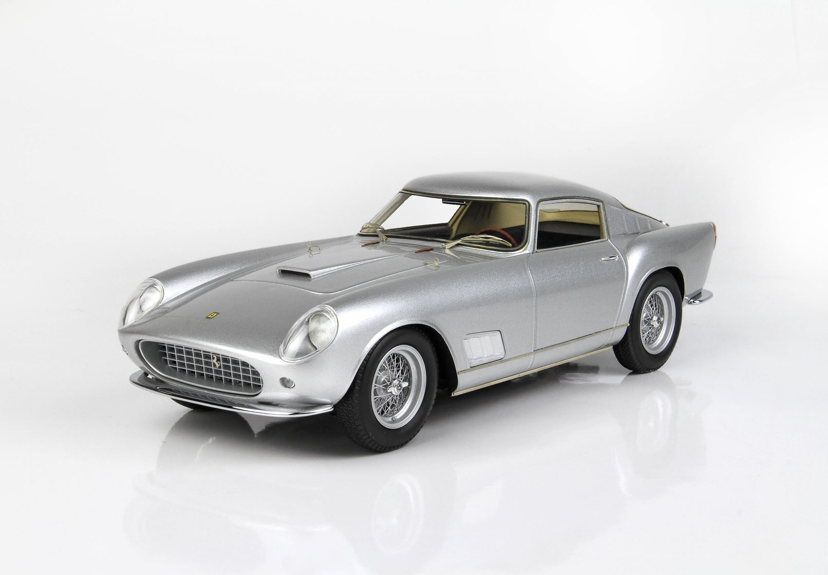 Silver classic sports car model with wire wheels and detailed front grille, offered on Vroomi