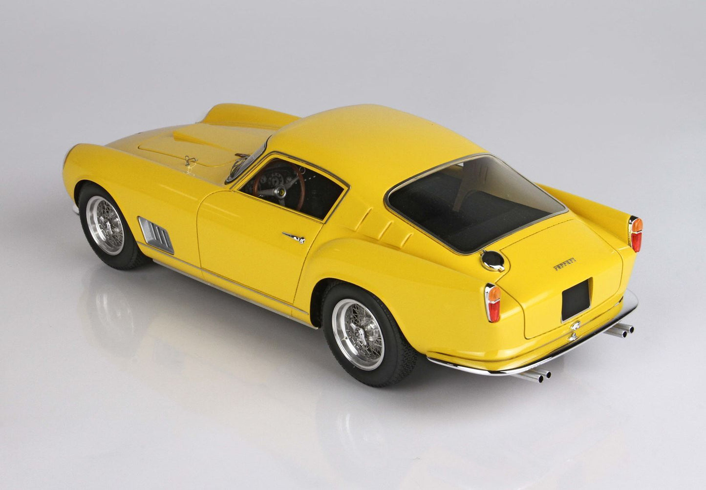 Modèle réduit vintage Ferrari jaune avec détails chromés et roues à rayons, proposé sur la plateforme Vroomi.