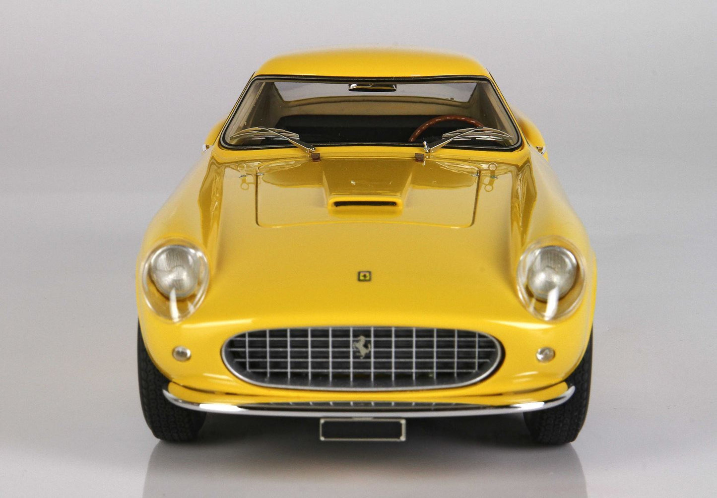 Vue avant d'une voiture Ferrari vintage jaune avec calandre chromée, disponible sur la plateforme Vroomi.