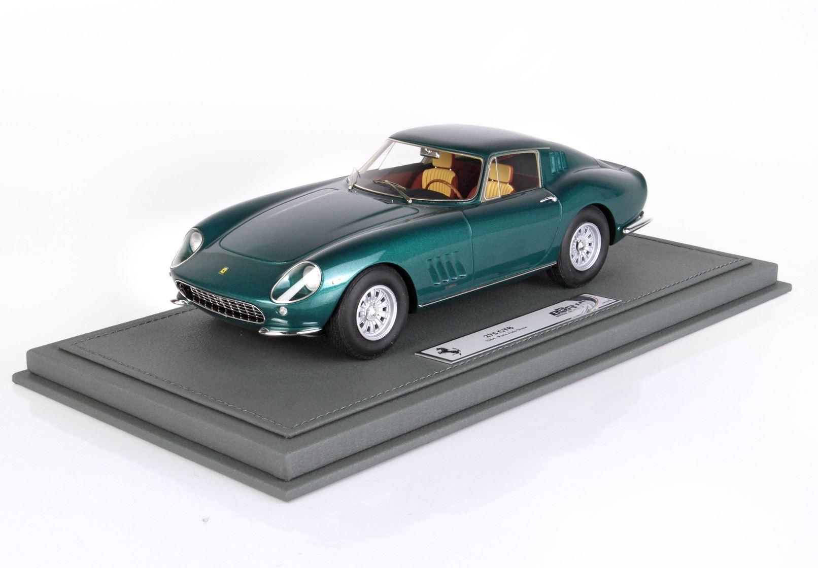 Green Ferrari 275 GTB model car with tan interior on gray display base, offered through Vroomi