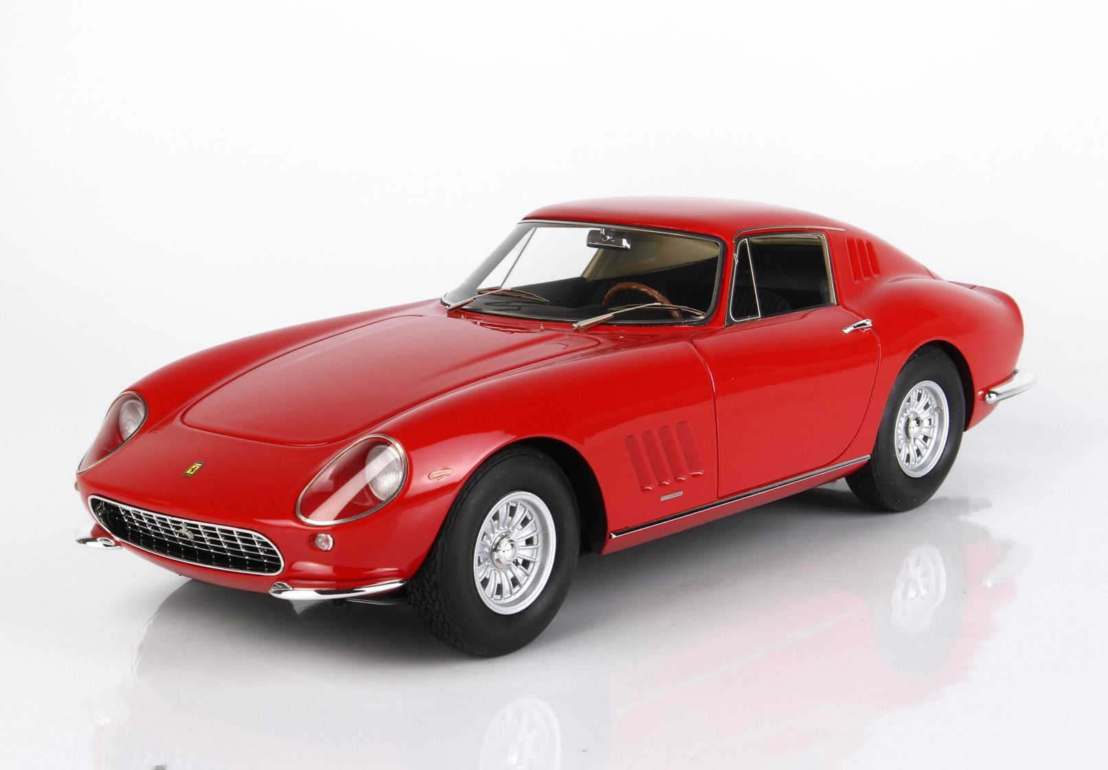 Classic red vintage Ferrari model car with chrome wheels, shown on a white background, now offered on Vroomi