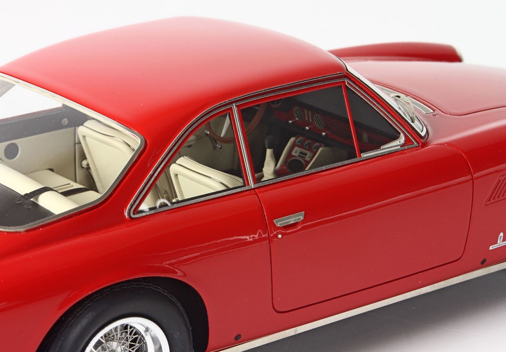 Close-up of a red classic sports car model showing white leather interior and detailed dashboard, now offered on Vroomi