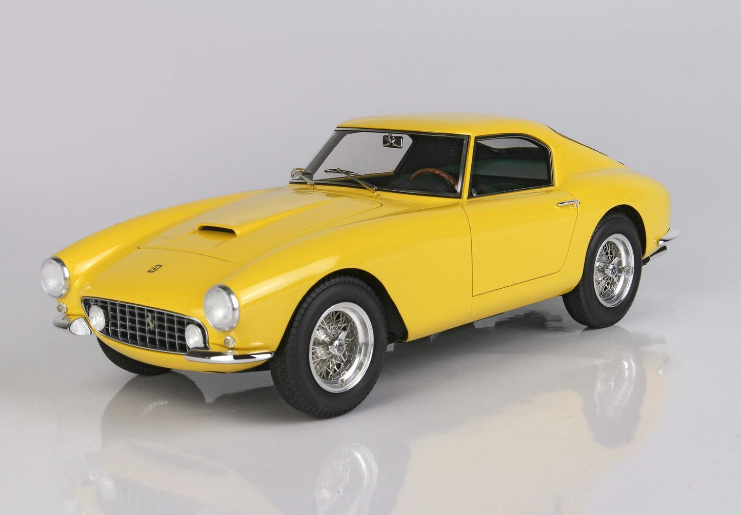 Modèle réduit classique de voiture de sport Ferrari jaune avec jantes à rayons chromées, disponible sur la plateforme Vroomi.
