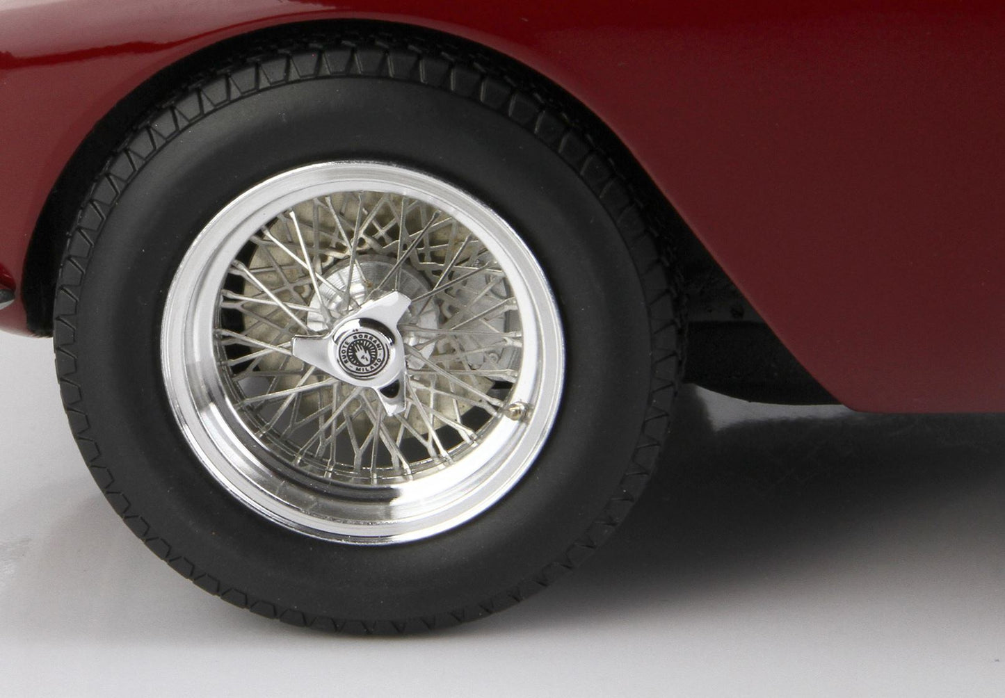 Gros plan sur la roue à rayons métalliques d'une voiture classique avec enjoliveur amovible sur une carrosserie marron, disponible sur Vroomi.