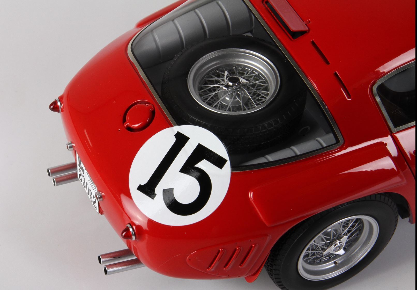 Close-up of rear red classic race car model with number 15 and spare tire, offered on Vroomi