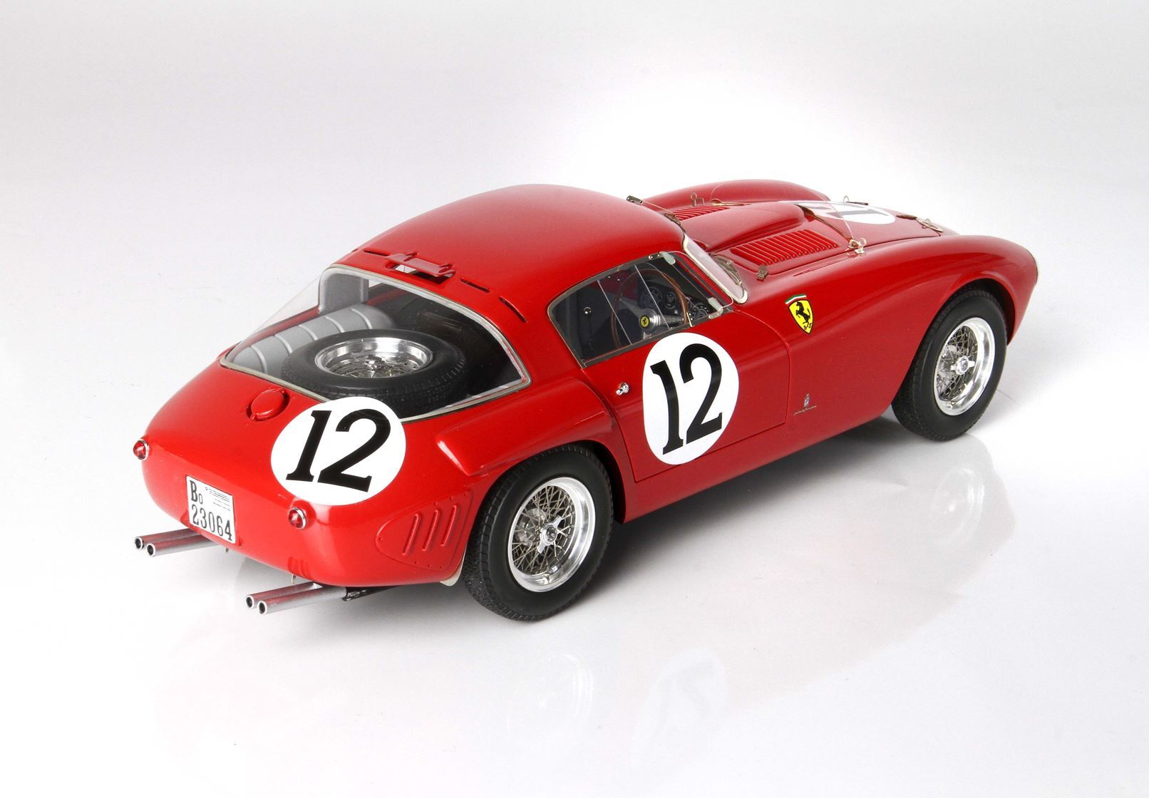 Red vintage Ferrari race car model with number 12 on doors and rear, spare tire, available on Vroomi