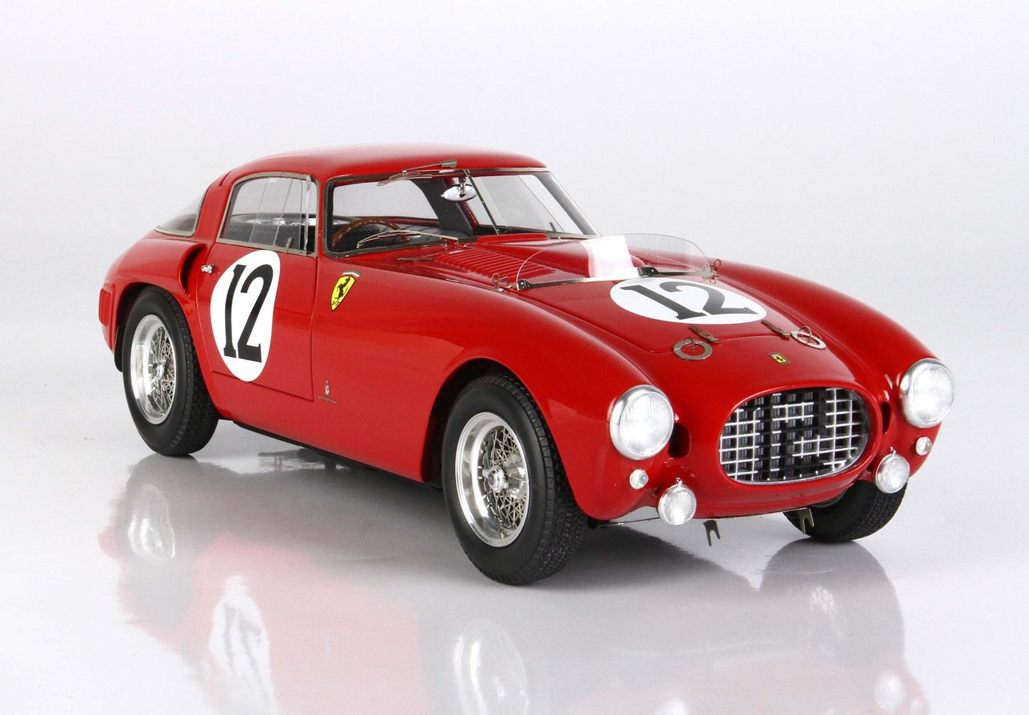 Vintage red Ferrari race car with number 12 on door and hood, classic design, now featured on Vroomi