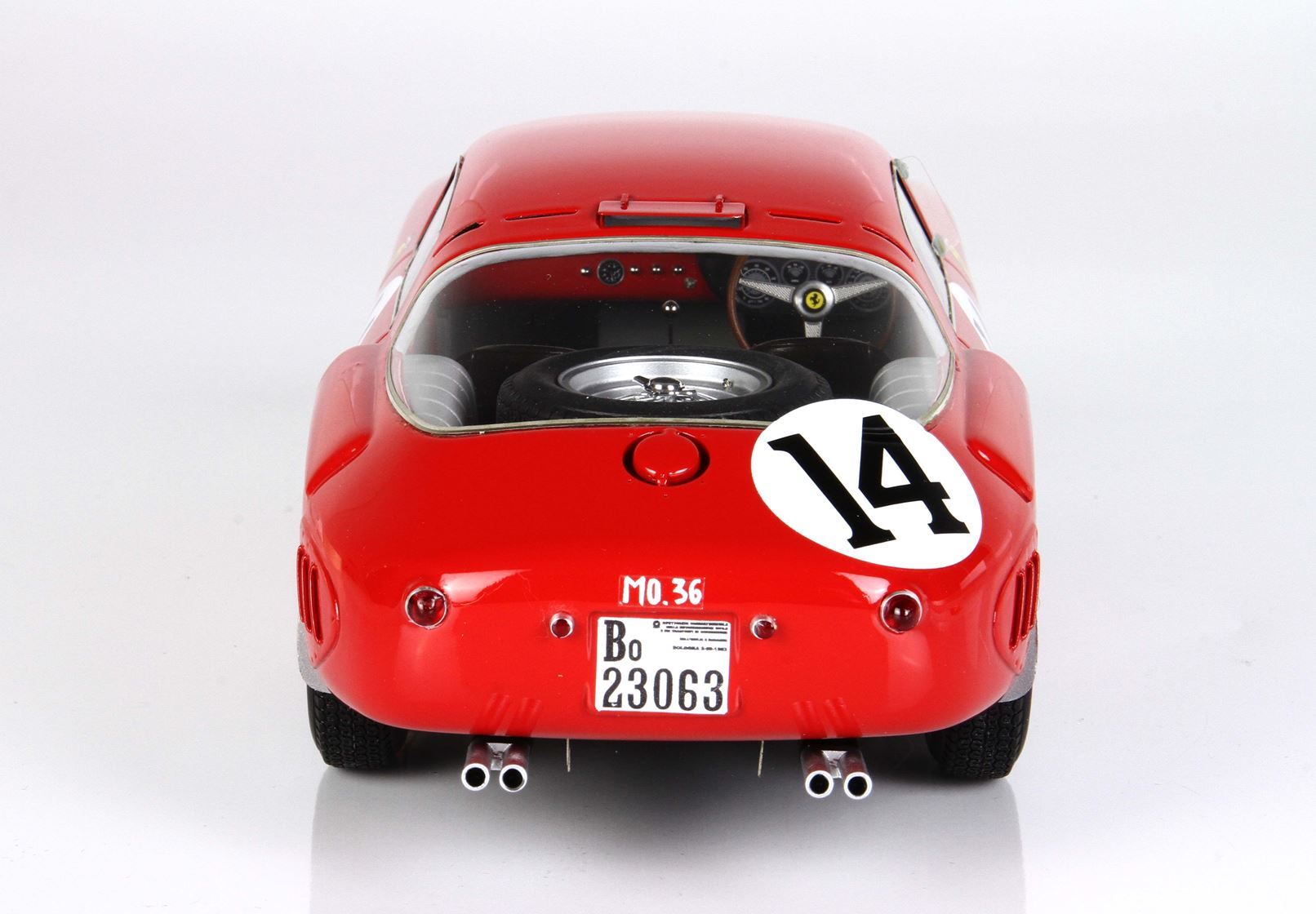 Rear view of red vintage race car model with number 14, spare tire inside, and dual exhausts, now offered on Vroomi