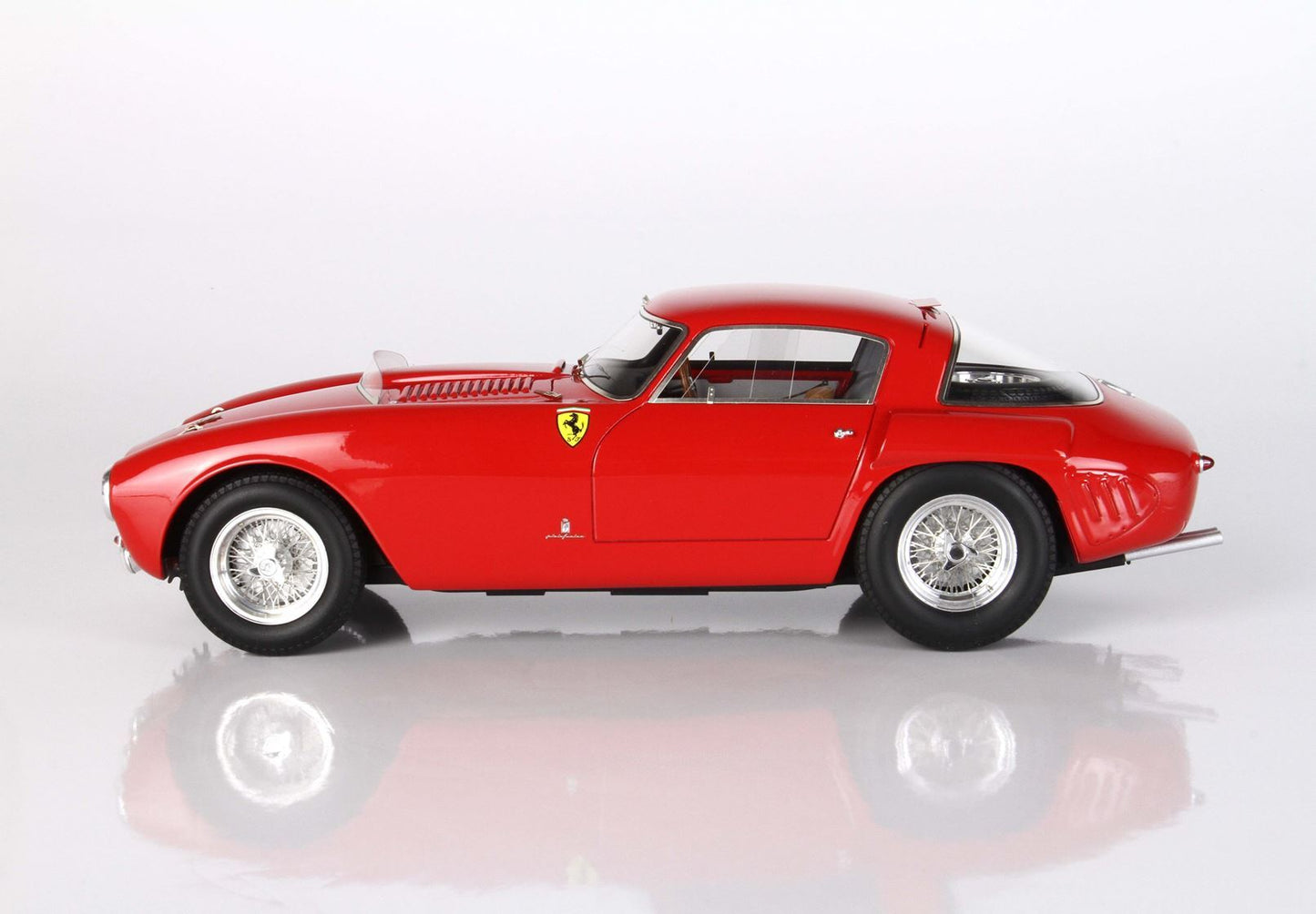 Side view of a classic red Ferrari vintage sports car with wire-spoke wheels, offered on Vroomi platform