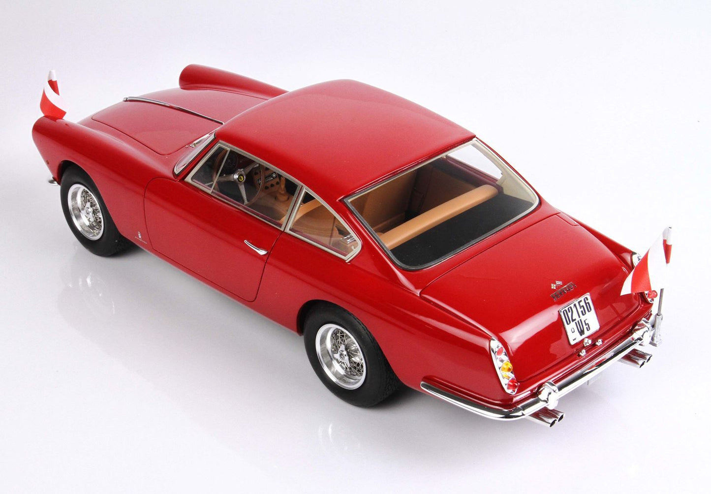 Modèle réduit Ferrari classique rouge avec détails chromés et drapeaux, disponible sur la plateforme Vroomi.