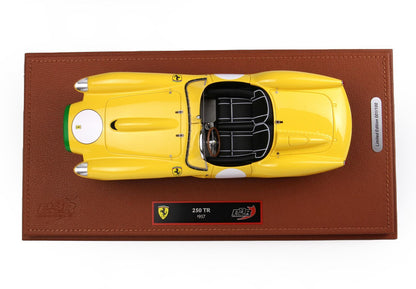 Top view of yellow 1957 Ferrari 250 TR model on brown leather base with plaque, available on Vroomi