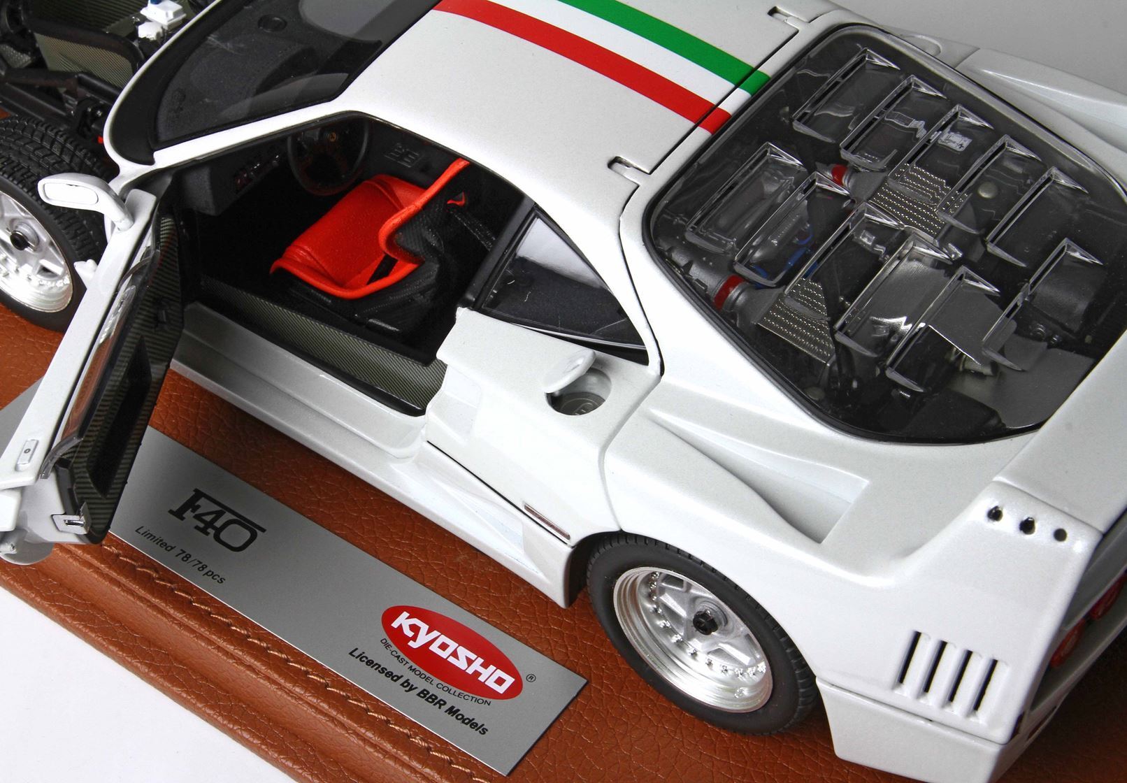 White Kyosho F40 diecast model with open door showing red interior, displayed on leather base, available on Vroomi