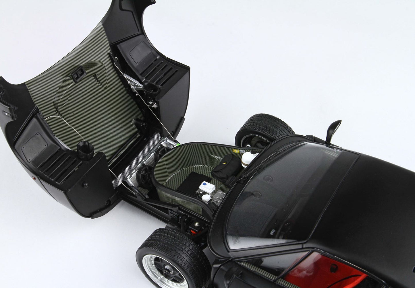 Black sports car front trunk open revealing carbon fiber interior details and components, available on Vroomi platform