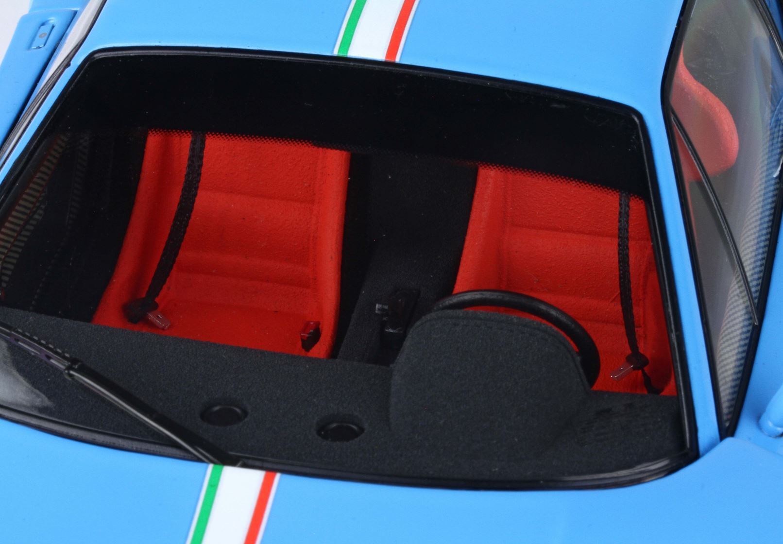 Blue sports car interior with red seats, black dashboard and steering wheel, available through Vroomi