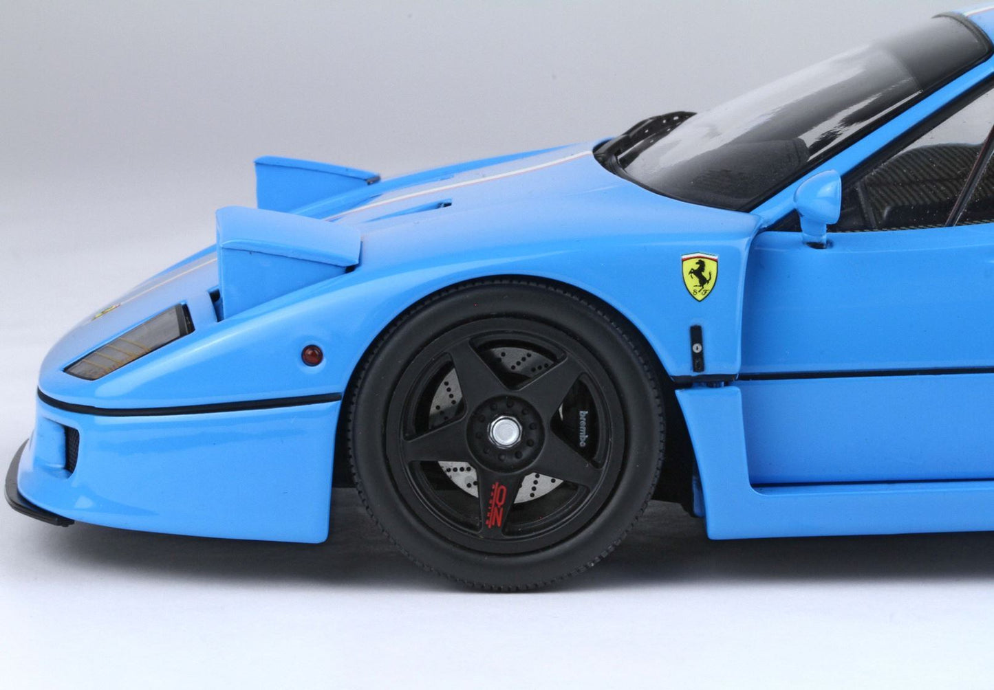Close-up of blue Ferrari F40 front side with black OZ Racing wheel and Brembo brakes, available on Vroomi
