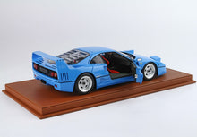 Modèle réduit de Ferrari F40 bleue avec porte ouverte sur socle en cuir marron, disponible chez Vroomi.