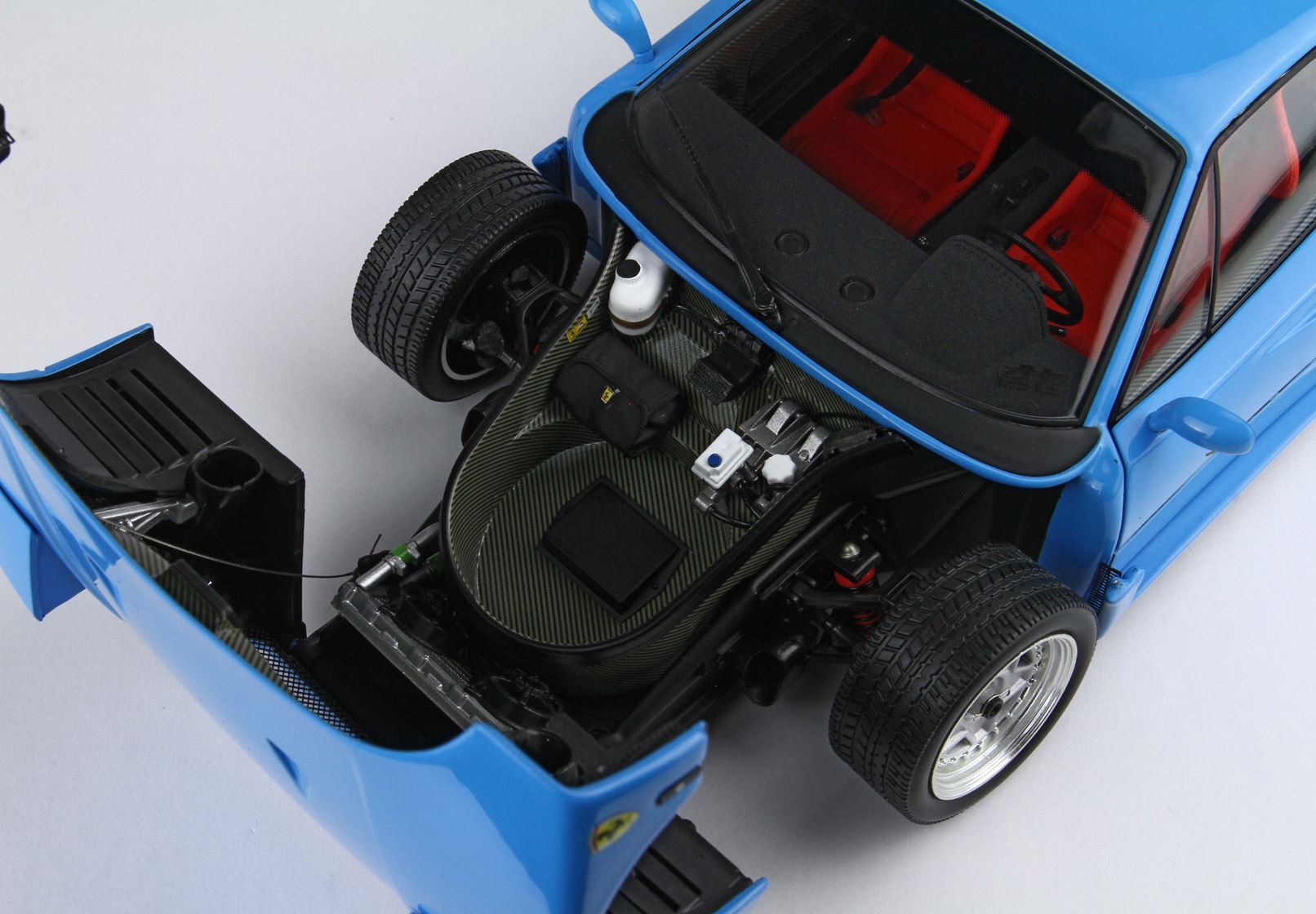 Coffre avant bleu classique pour voiture de sport avec composants détaillés et intérieur rouge, désormais disponible sur Vroomi.