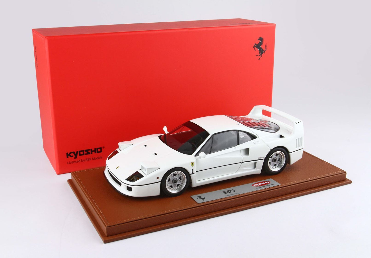 White Ferrari F40 model car on brown display base with red Kyosho box, also available on Vroomi