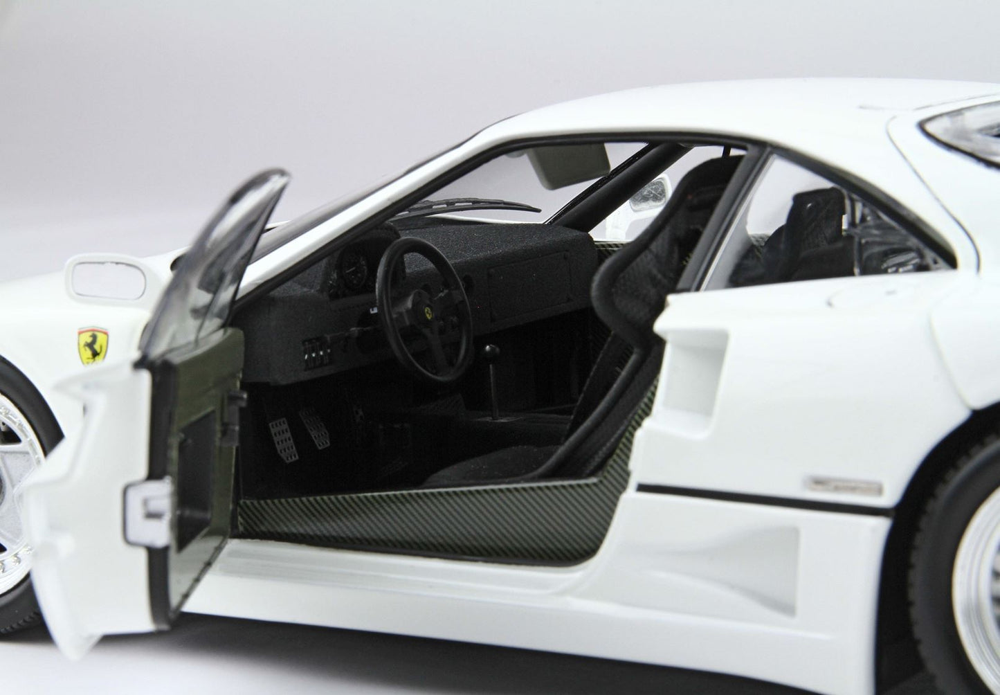 White Ferrari model car with open door showing detailed black racing interior, available on Vroomi