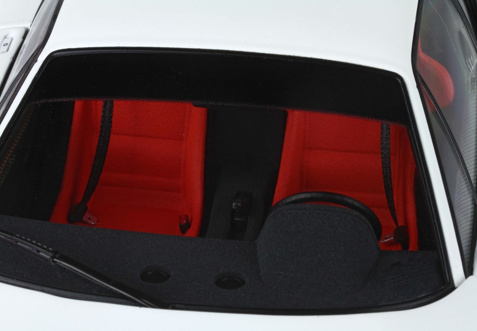 White sports car interior with vibrant red seats and black dashboard, available on Vroomi