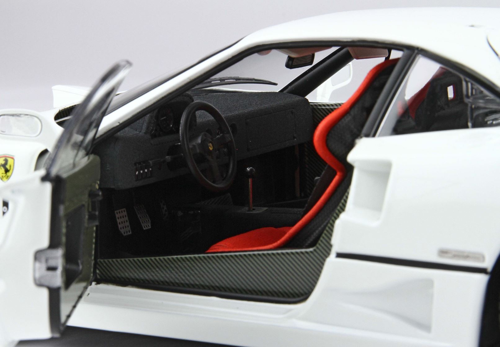 Interior view of white Ferrari model car with open door and red racing seat, offered on Vroomi