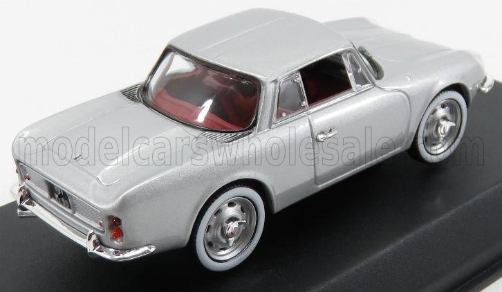 Modellino di auto classico in metallo argentato con interni rossi, esposto su una piattaforma nera, disponibile tramite Vroomi.