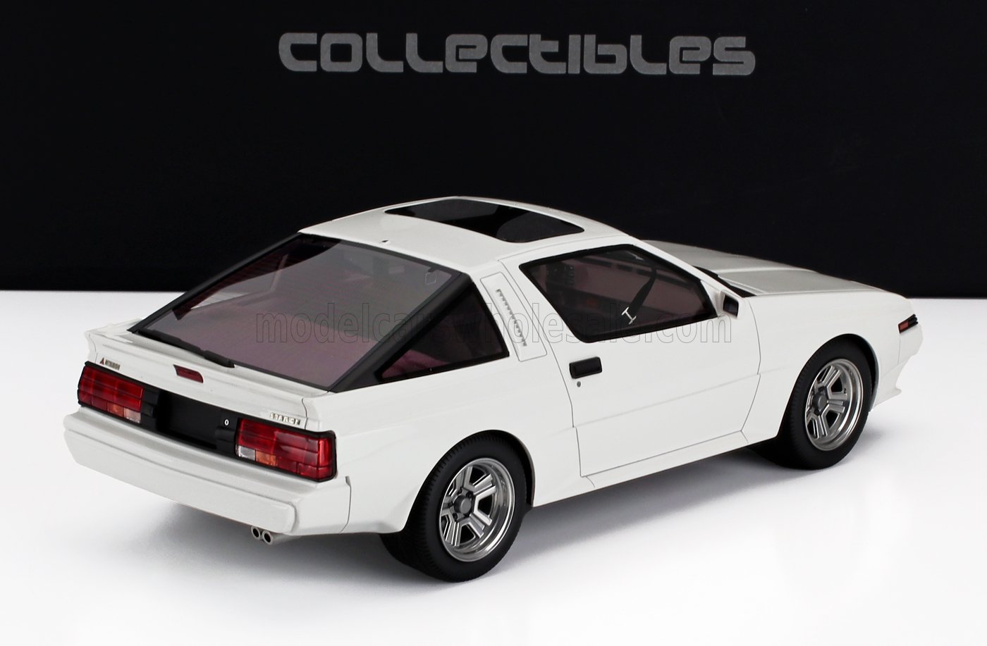 Modellino vintage bianco Mitsubishi Starion con tetto apribile, spoiler posteriore e cerchi argentati, in vendita su Vroomi.