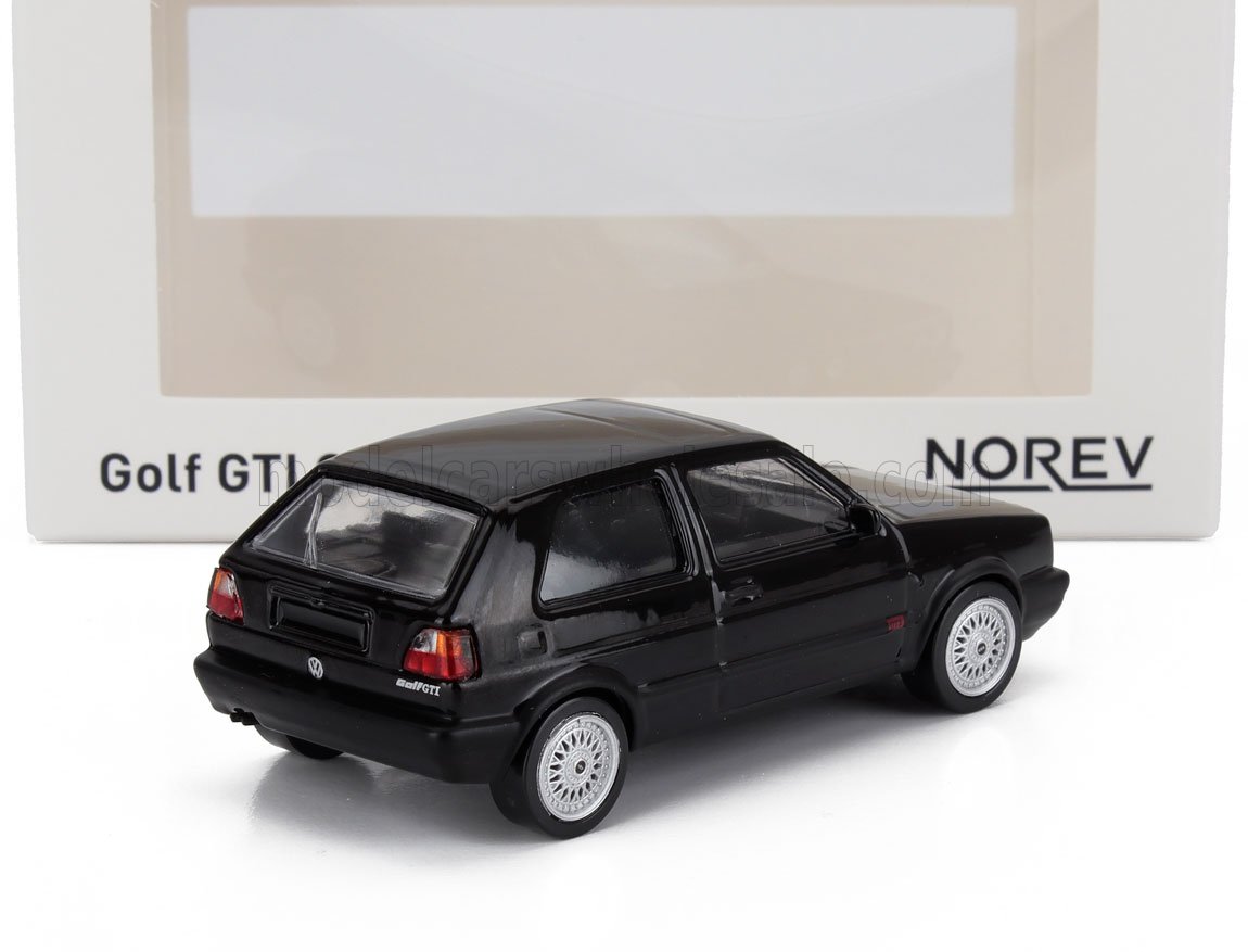 Modellino di auto VW Golf GTI nera di Norev esposto con confezione, disponibile su Vroomi