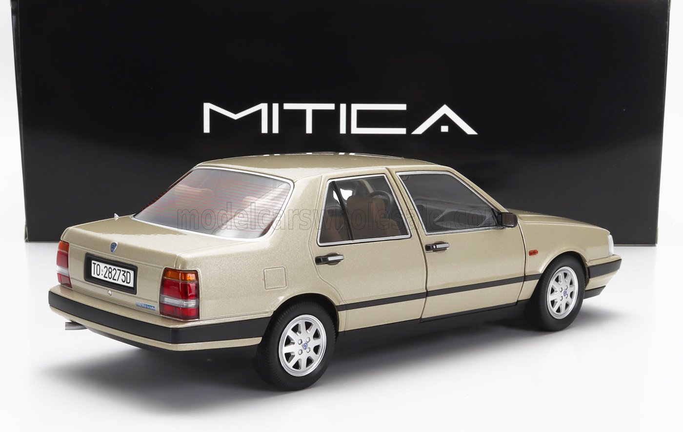 Modellino classico beige della Lancia Thema esposto davanti a una scatola nera MITICA, in vendita su Vroomi.