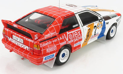 Modellino in scala 1/18 dell'auto da rally Audi con livrea da gara rossa, bianca e blu, disponibile su Vroomi.