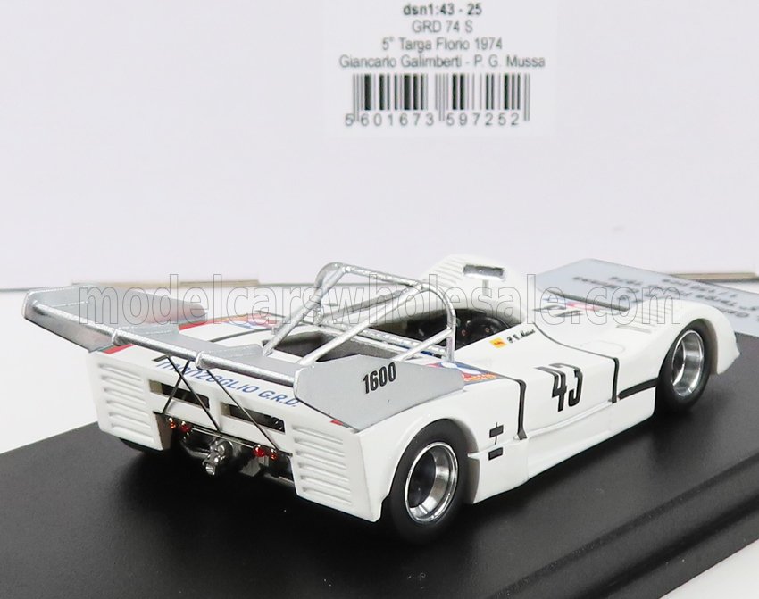 Modello di auto da corsa Targa Florio del 1974, bianca, con il numero 43 e 1600 sull'alettone posteriore, in mostra su una piattaforma espositiva, ora accessibile tramite Vroomi.