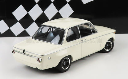 Modello classico di auto d'epoca bianca compatta su sfondo a scacchi bianchi e neri, disponibile tramite Vroomi.