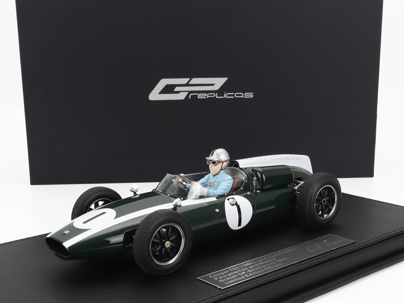 Replica di un'auto da corsa Cooper T53 del 1960, verde scuro, con figurina del pilota, disponibile su Vroomi.