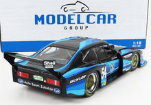 Modellino di auto da corsa Porsche in scala 1:18, nero e blu, con i loghi degli sponsor, disponibile su Vroomi.
