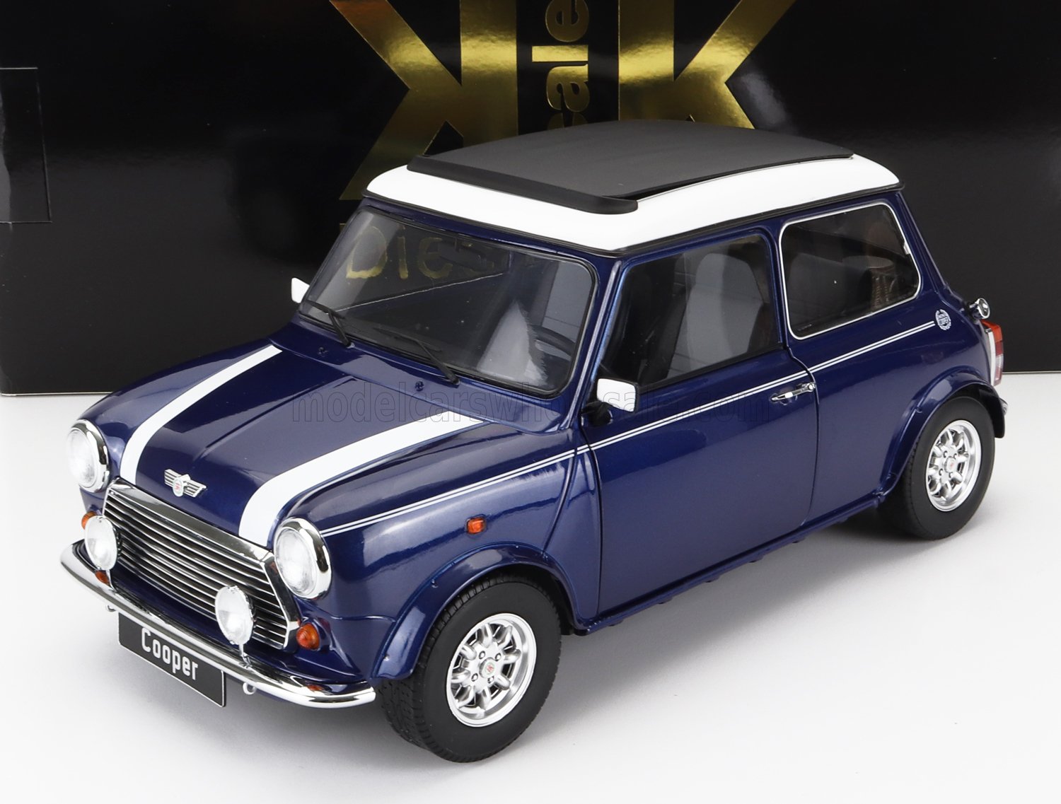 Modellino di auto Mini Cooper classica blu con tetto bianco e strisce da corsa, presente su Vroomi.