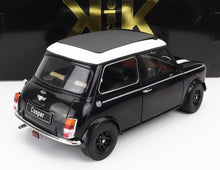 Modellino in bianco e nero della classica Mini Cooper esposto all'interno, disponibile anche tramite Vroomi.