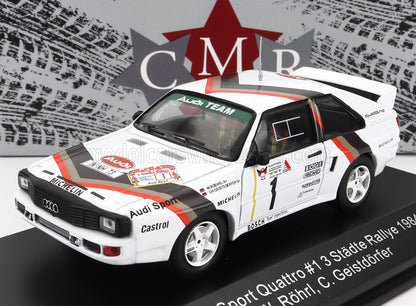 Modellino di auto da rally Audi Sport Quattro bianca con adesivi da corsa su espositore nero, disponibile su Vroomi.
