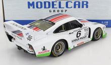 Modellino in scala di un'auto da corsa Porsche 935 bianca con livrea Liqui Moly, strisce rosse e blu, adesivi dettagliati e spoiler posteriore disponibile su Vroomi.