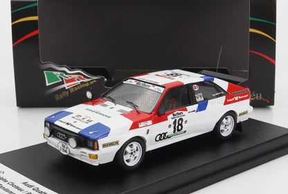 Modellino dell'auto da rally Audi Quattro nei colori rosso, bianco e blu su espositore, disponibile tramite Vroomi.