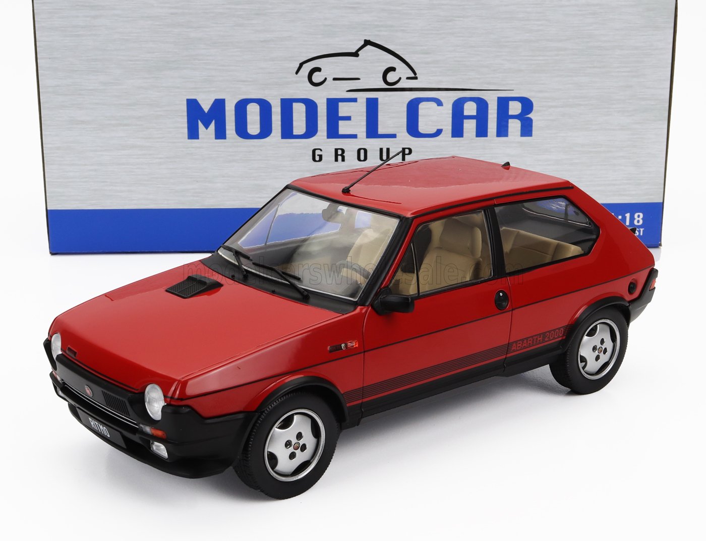 Modellino in scala 1/18 della Fiat Ritmo Abarth 2000 rossa con interni beige, esposto nella confezione Modelcar Group, disponibile su Vroomi.