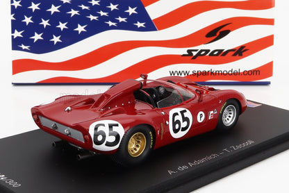 Modellino di auto da corsa vintage rossa numero 65 con ruote dorate su base nera, bandiera americana e logo Spark sullo sfondo, disponibile su Vroomi.