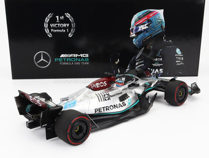 Modellino di auto Mercedes AMG Petronas Formula 1 con casco di George Russell sullo sfondo, disponibile su Vroomi.