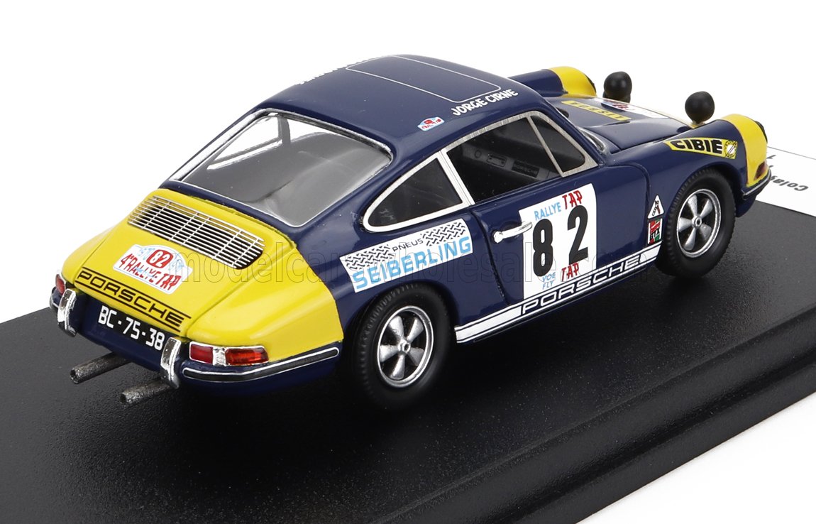Modellino di auto da rally Porsche 911 blu e gialla con il numero 82 su sfondo nero, disponibile su Vroomi.
