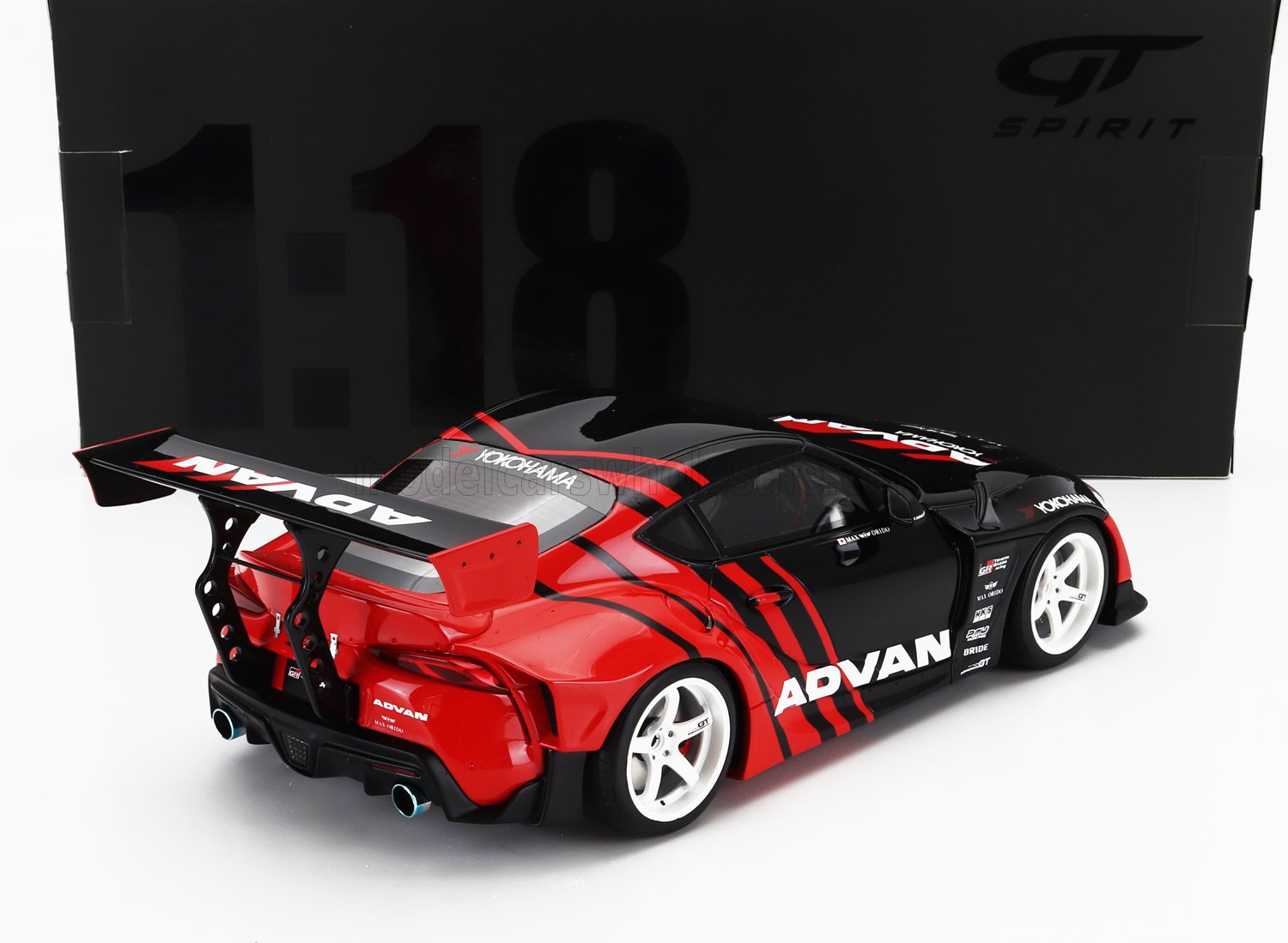 Modello di auto da corsa GT Advan in scala 1:18, nero e rosso, con grande alettone posteriore e ruote bianche, disponibile su Vroomi.