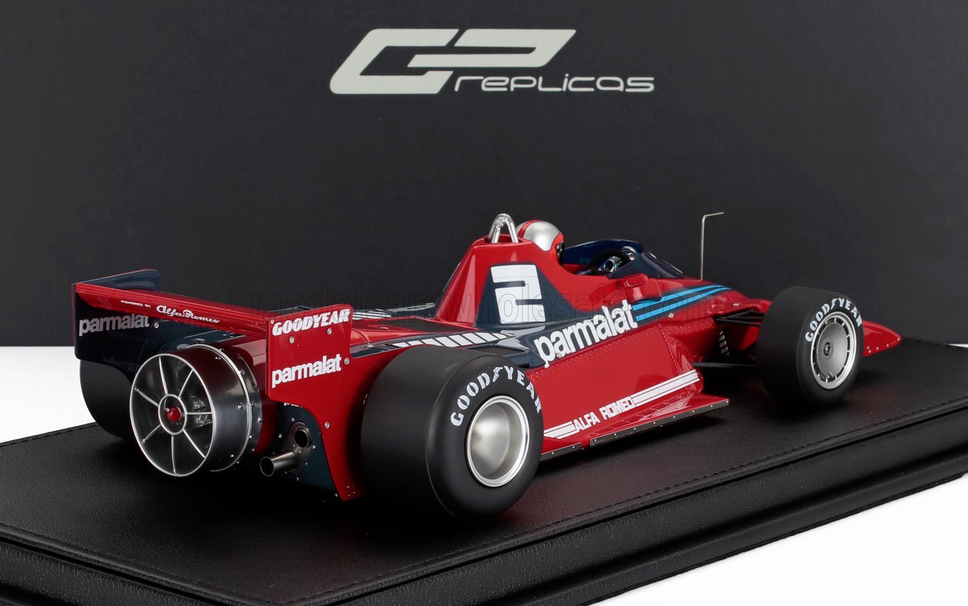 Modellino di auto da corsa Alfa Romeo Parmalat Formula 1 rossa con pneumatici Goodyear, esposto su base nera, disponibile su Vroomi.