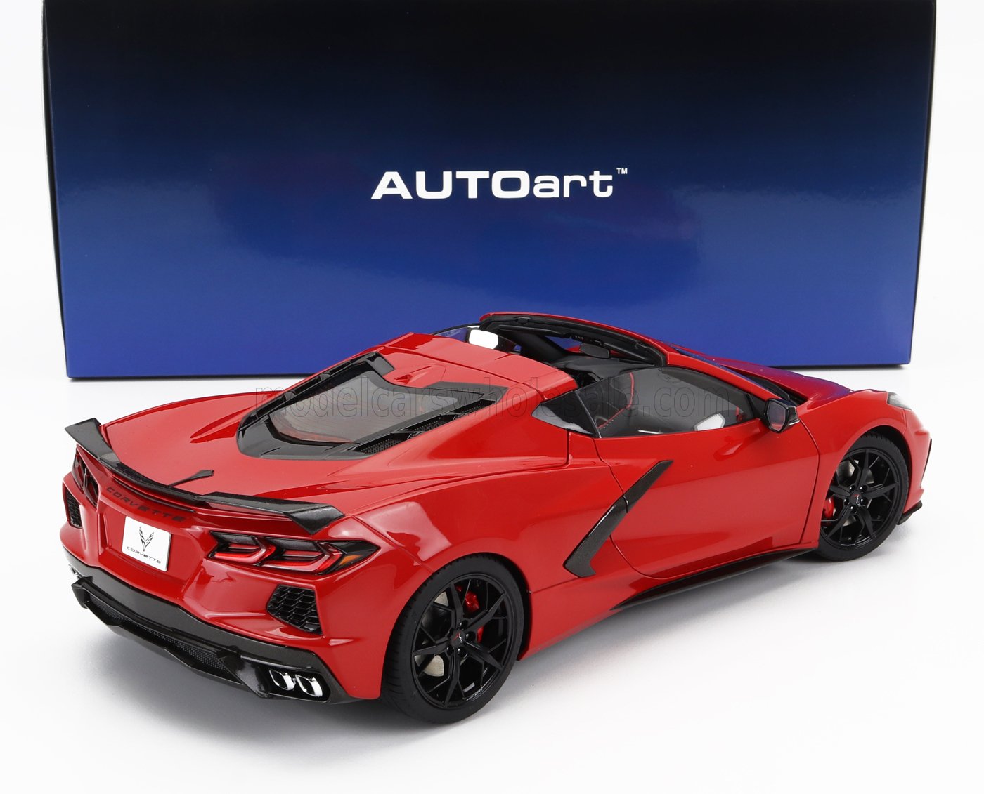 Modellino rosso di auto sportiva Corvette AUTOart con cerchi neri, presentato in una scatola blu AUTOart, disponibile tramite Vroomi.